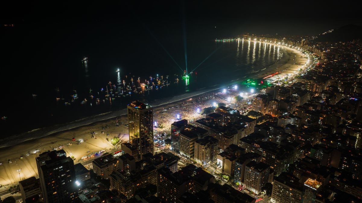 Praia de Copacabana lotada e iluminada na noite de Réveillon